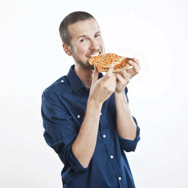 Portrait of a young beautiful man eating a slice of pizza margherita — Stock Photo, Image