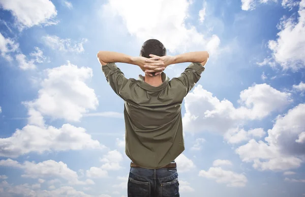 Jonge man genieten van vrijheid op blauwe hemelachtergrond — Stockfoto