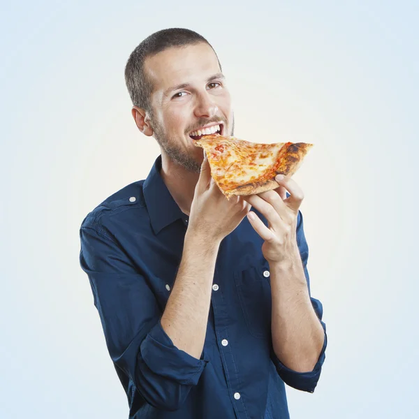 Porträt eines jungen schönen Mannes, der ein Stück Pizza Margherita isst — Stockfoto