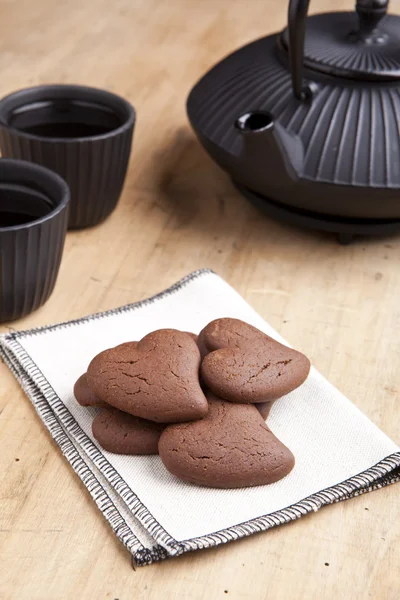 Deliciosos biscoitos em forma de coração de chocolate com chá — Fotografia de Stock