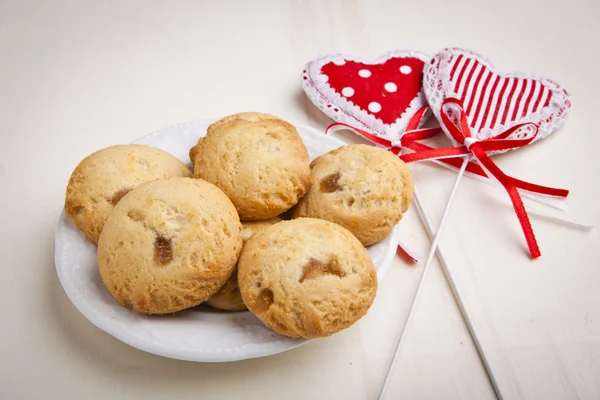 Delicious apple biscuits on wooden table with heart decorations — Stock Photo, Image