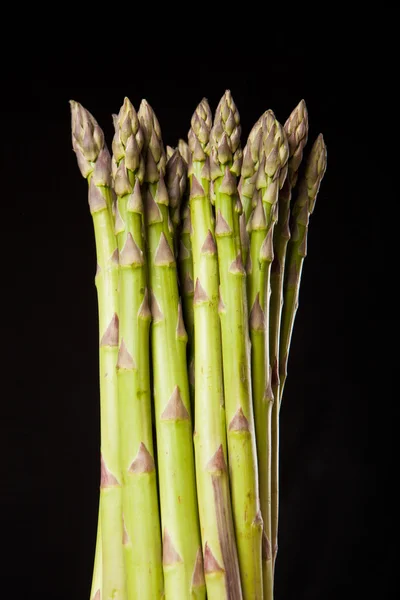 Bunch of fresh green asparagus on black background — Stock Photo, Image