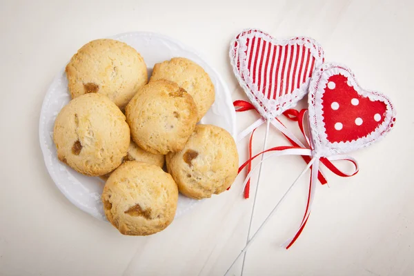 Delicious apple biscuits on wooden table with heart decorations — Stock Photo, Image