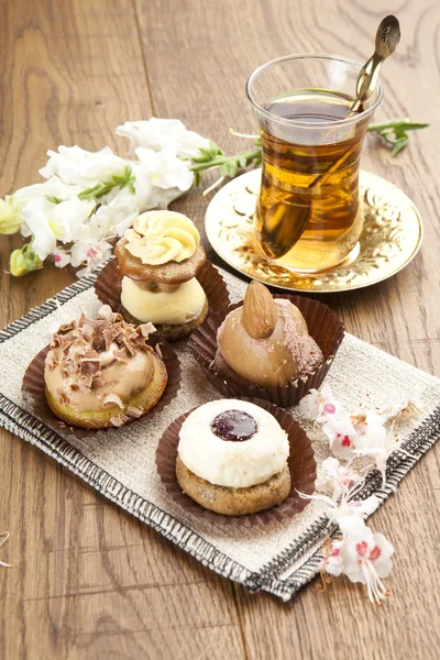 Tipo diferente de bela pastelaria, pequenos bolos doces coloridos com chá — Fotografia de Stock