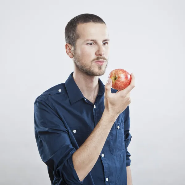 Alegre hermoso hombre comiendo manzana, aislado sobre fondo blanco — Foto de Stock