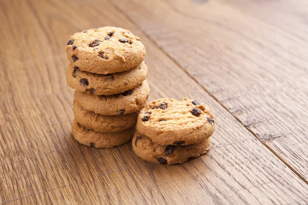 Pila de galletas de chocolate con chocolate en la mesa de madera — Foto de Stock