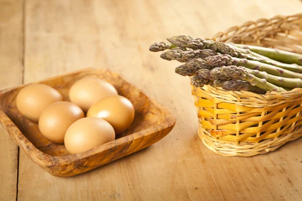 Espargos e ovos na mesa de madeira, ingredientes — Fotografia de Stock