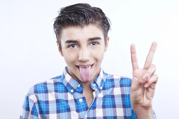 Portrait of handsome young boy showing victory sign on white background — Stock Photo, Image