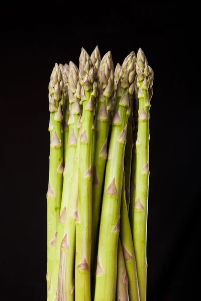 Bunch of fresh green asparagus on black background — Stock Photo, Image