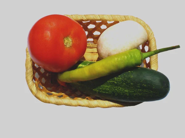 kırmızı domates, salatalık, yeşil biber ve mantar bir sepet içinde yatıyordu.