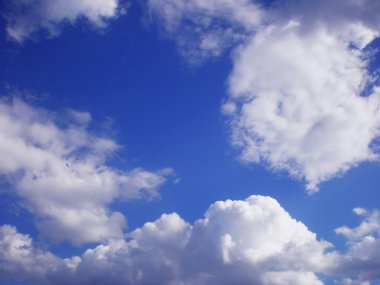 Parlak mavi gökyüzü beyaz hava bulutlar float. Son derece gökyüzünde kuş uçar.
