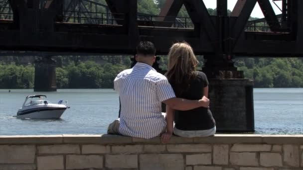 Una joven pareja usa un portátil inalámbrico afuera en el parque — Vídeo de stock