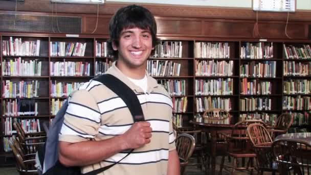 Um estudante confiante orgulhosamente olha para a câmera e sorri — Vídeo de Stock