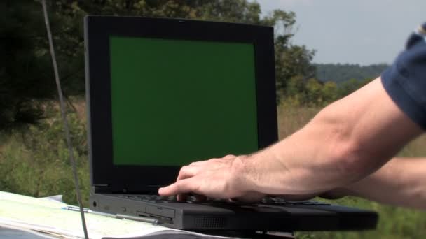 Usando um laptop no campo. Alpha matte incluído — Vídeo de Stock