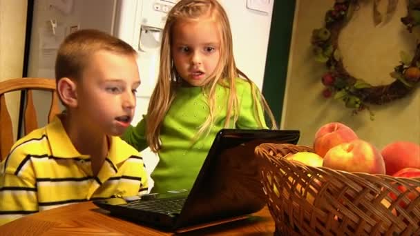 Küçük çocuklar mutfakta bir dizüstü bilgisayar kullanmak — Stok video