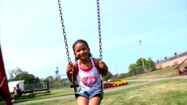 Une jeune fille balance sur un ensemble de balançoire — Video