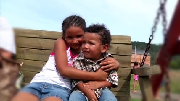 Un abrazo de hermano y hermana en un columpio — Vídeo de stock