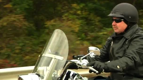 Велосипедист ездит на мотоцикле осенью — стоковое видео