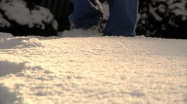 Ayakları karda yürüyen bir close-up. yüklenmiş.
