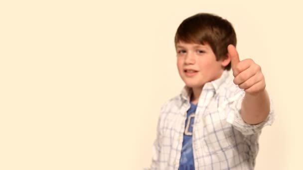 Um menino dá à câmera um polegar para cima . — Vídeo de Stock