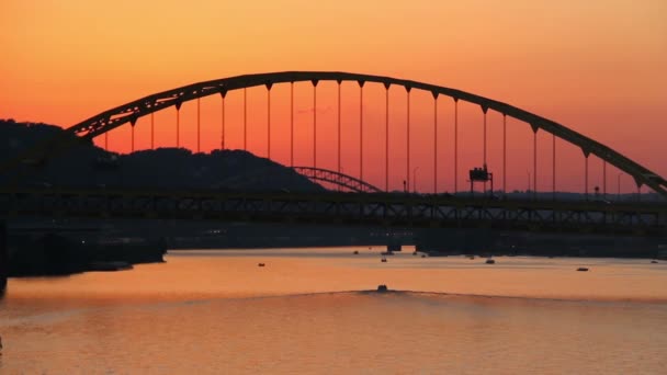 Provoz prochází přes fort pitt mostu během soumraku v Pittsburghu, pa jako výletní lodě cestovat pod. — Stock video