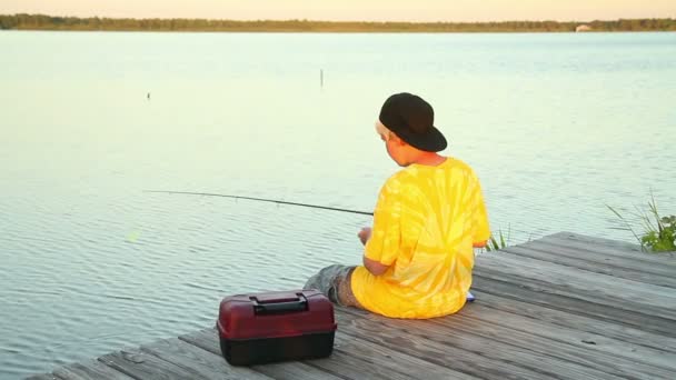 A young boy fishes in the early evening. — Stock Video