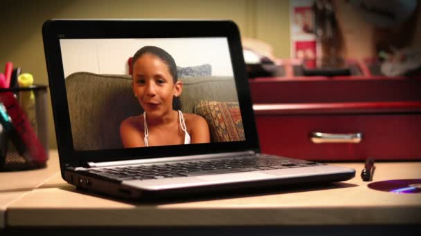 Ein junges Mädchen chattet auf einem tragbaren Laptop. — Stockvideo