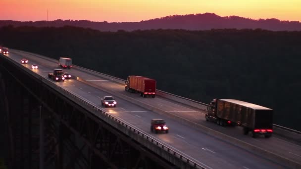 Verkeer gaat voorbij aan de new river gorge brug over de rivier van de new in de schemering. — Stockvideo