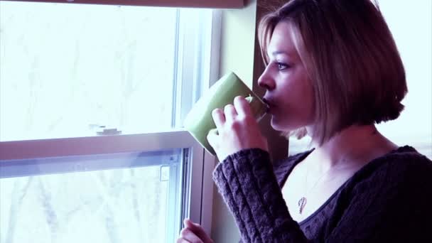 Une femme déprimée regarde par la fenêtre . — Video