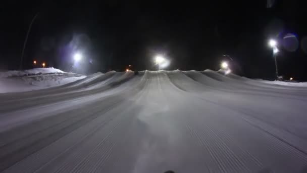 Ridning nerför en snow tubing kulle på natten. — Stockvideo