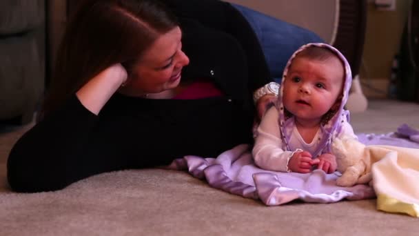 A mother plays with her new born daughter in her home. — Stock Video