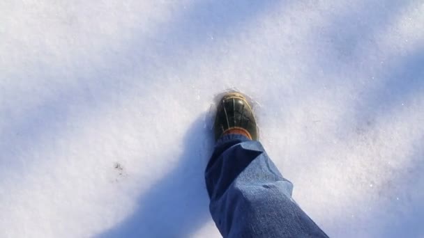 Un hombre camina con cuidado sobre el hielo en el frío invierno . — Vídeo de stock