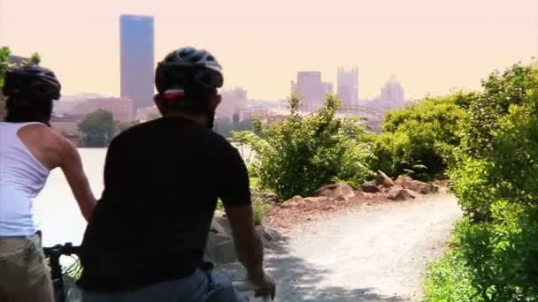 Egy fiatal pár kerékpár és feledkezzen el a mindennapokról a kerékpárúton — Stock videók
