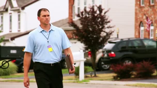 Un vendeur porte à porte marche dans un quartier . — Video