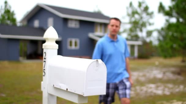 Ein Mann checkt seine Post vor seinem Haus. — Stockvideo