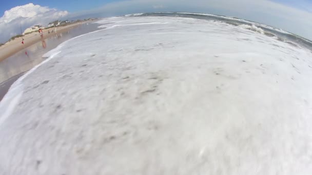 Un ojo de pez mira el oleaje en una playa . — Vídeo de stock