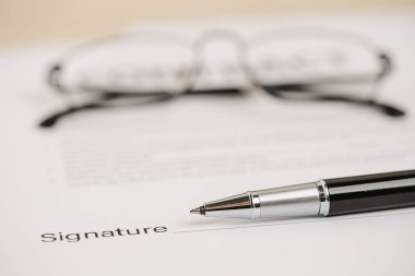 Kalemler ve sözleşme belgeleri masanın üzerine konur..