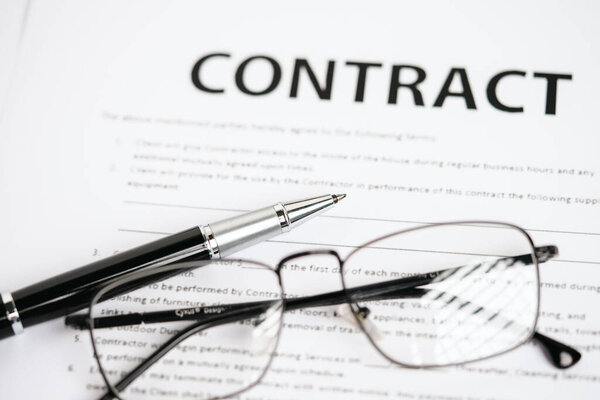 Ручки и договорные документы лежат на столе.