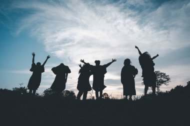 Group of teamwork people jump freedom happy playing at summer sunset in nature