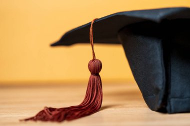 Siyah Mezuniyet Şapkası ahşap masa arkasına yerleştirildi