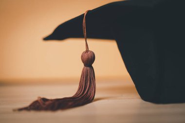 Siyah Mezuniyet Şapkası ahşap masa arkasına yerleştirildi