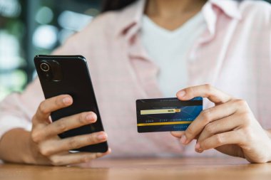 Akıllı telefon kullanarak online alışveriş ve ödeme konsepti kullanarak kredi kartı tutan eller