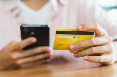 Akıllı telefon kullanarak online alışveriş ve ödeme konsepti kullanarak kredi kartı tutan eller