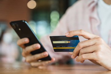 Akıllı telefon kullanarak online alışveriş ve ödeme konsepti kullanarak kredi kartı tutan eller