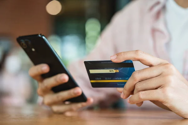 Akıllı telefon kullanarak online alışveriş ve ödeme konsepti kullanarak kredi kartı tutan eller