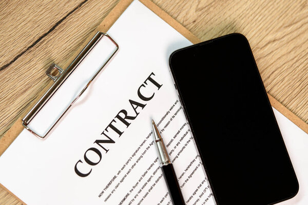 Контракт подписи ручки и смартфона на бумажном фоне
