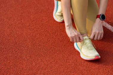 Sabahları spor ayakkabılarına ayakkabı bağlayan koşucu kadınların elleri yakındır.
