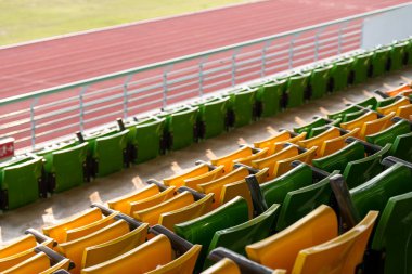 Arenadaki futbol stadyumunda boş plastik stadyum koltukları.