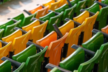 Arenadaki futbol stadyumunda boş plastik stadyum koltukları.