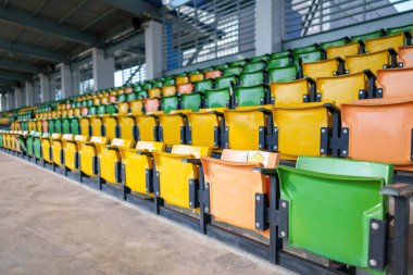 Arenadaki futbol stadyumunda boş plastik stadyum koltukları.